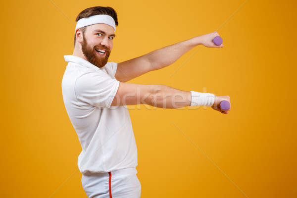 Side view of smiling sportsman with lightweight dumbbells Stock photo © deandrobot