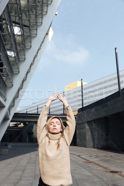 Serious young blonde lady standing with eyes closed outdoors. Stock photo © deandrobot