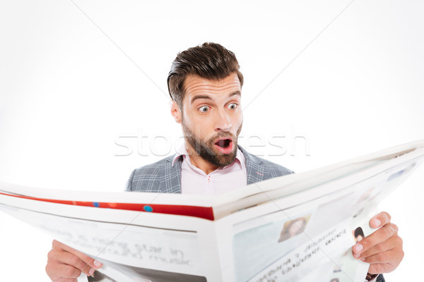 Shocked young man reading gazette. Stock photo © deandrobot
