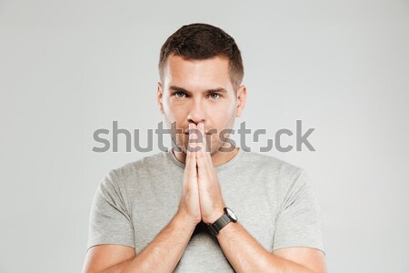 Serious man prays. Stock photo © deandrobot