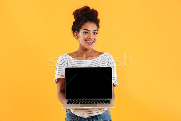 Young beautiful lady with curly hair showing laptop computer isolated Stock photo © deandrobot