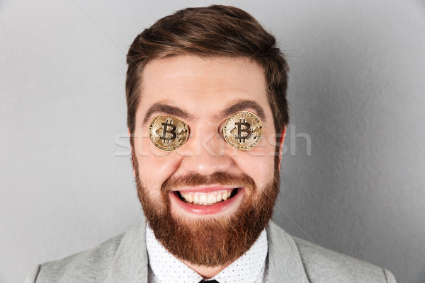 Close up of a happy businessman with bitcoins Stock photo © deandrobot
