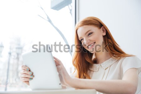 Photo of affable woman with long brown hair holding silver perso Stock photo © deandrobot