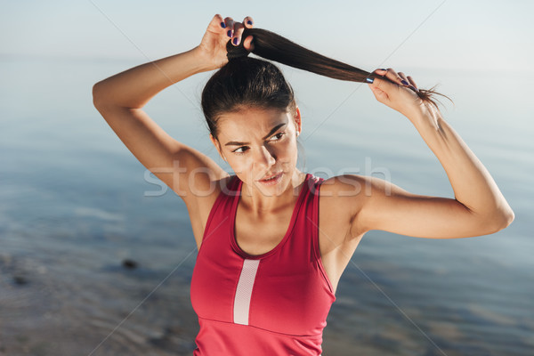 Confident young sportswoman doing stretching exercises Stock photo © deandrobot