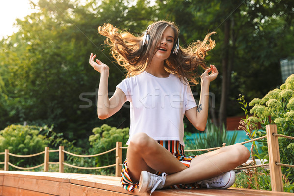 Freudige junge Mädchen Musik hören Kopfhörer Park Freien Stock foto © deandrobot