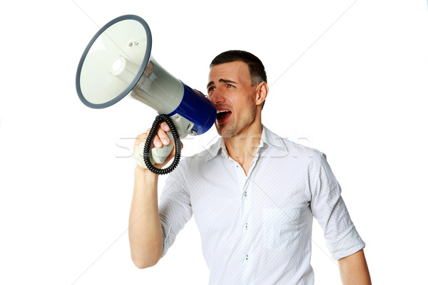Portrait of a man roaring loudly into megaphone over white background Stock photo © deandrobot