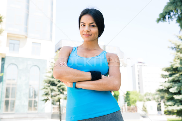 Sports woman standing with arms folded outdoors Stock photo © deandrobot