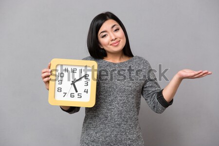 Nervous woman holding wall clock Stock photo © deandrobot