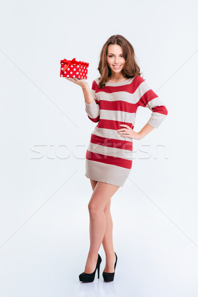 Smiling woman in dress holding gift box Stock photo © deandrobot