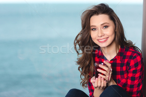 Smiling woman holding cup with tea Stock photo © deandrobot