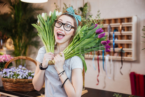 Funny happy woman florist holding two bunches of tulips  Stock photo © deandrobot