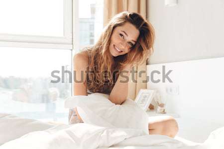 Woman in towel holding hairdryer on the bed Stock photo © deandrobot