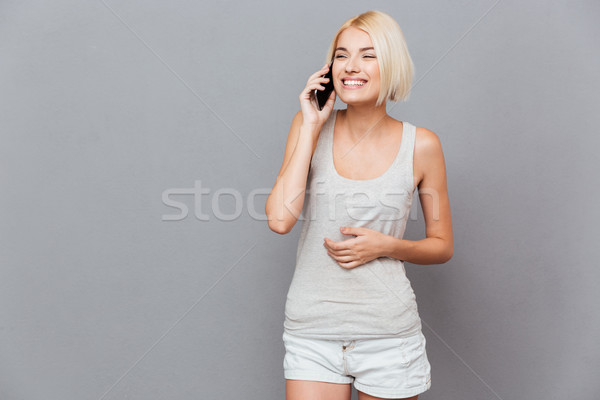 Güzel genç kadın konuşma cep telefonu gri Stok fotoğraf © deandrobot