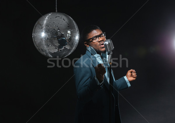 Afro amerian man singing into vintage microphone Stock photo © deandrobot