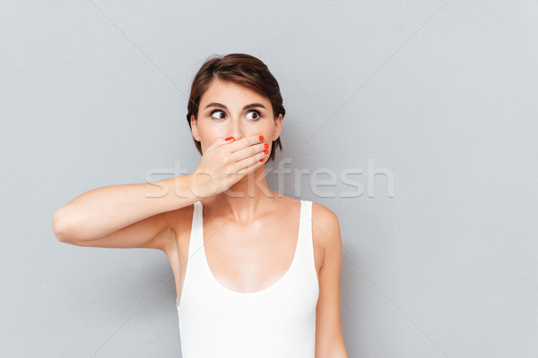 Fiatal nő befogja száját pálma izolált szürke nő Stock fotó © deandrobot
