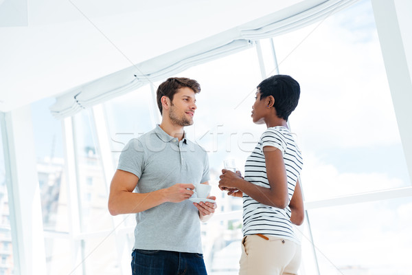 Stock photo: Two young business people standing and talking in office