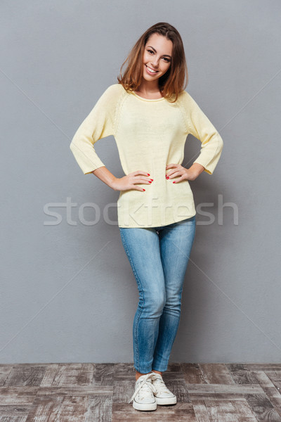 Woman standing with hands on hips and looking at camera Stock photo © deandrobot