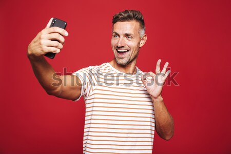 Young man in shirt showing blank smartphone screen Stock photo © deandrobot