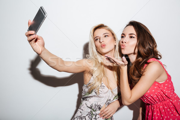 Barátok elvesz okostelefon fúj csók kamerába Stock fotó © deandrobot