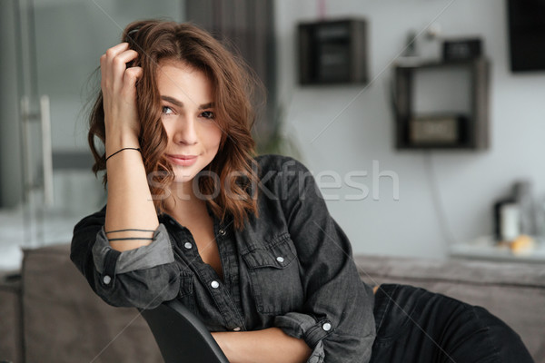 Happy woman sitting on chair at home indoors. Stock photo © deandrobot