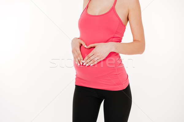 Cropped image of pregnant fitness woman Stock photo © deandrobot