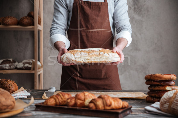 Foto junger Mann Bäcker halten Brot stehen Stock foto © deandrobot