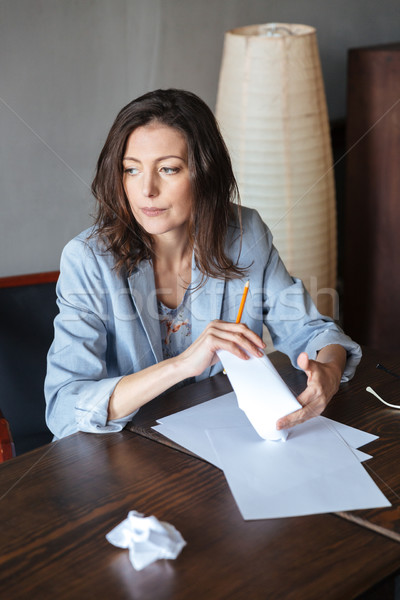 Thinking concentrated woman writer sitting indoors Stock photo © deandrobot