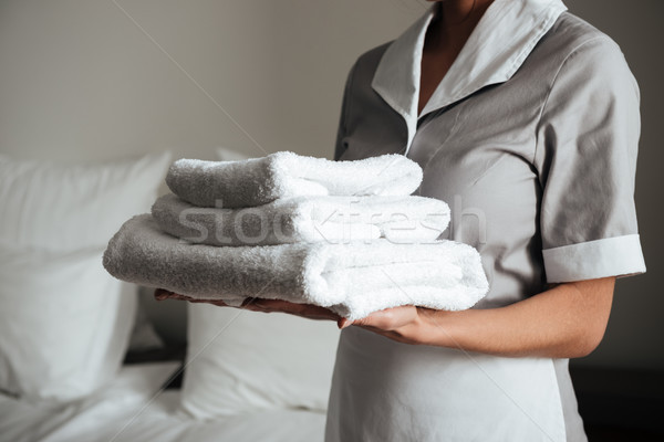 年輕 女傭 折疊 毛巾 圖像 商業照片 © deandrobot