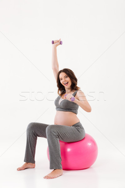 Vertical image of Smiling pregnant woman sitting on fitball Stock photo © deandrobot