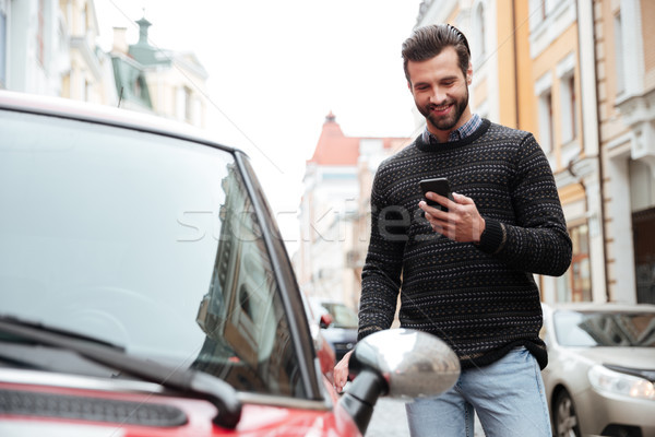 [[stock_photo]]: Portrait · satisfait · jeune · homme · chandail · téléphone · portable · permanent