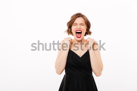 Portrait of an angry girl dressed in black dress screaming Stock photo © deandrobot
