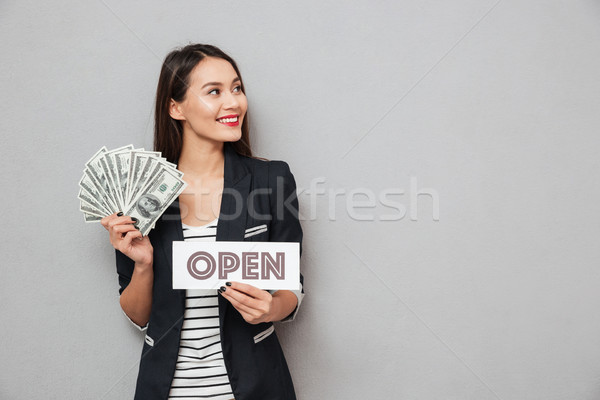 Happy asian business woman holding nameplat open and money Stock photo © deandrobot