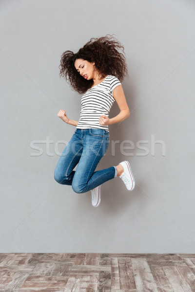 Concentrado mulher casual saltando sentimento legal Foto stock © deandrobot