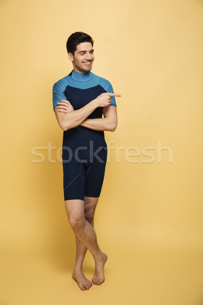 Cheerful young man dressed in swimsuit. Stock photo © deandrobot