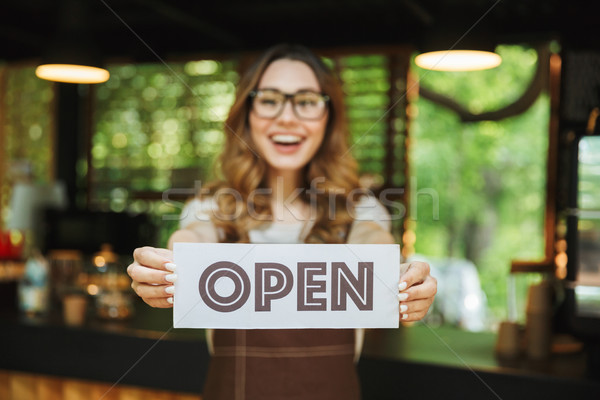 Portrait of a smiling young barista girl in apron Stock photo © deandrobot