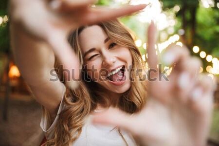 Close up of playful young girl showing frame with fingers Stock photo © deandrobot