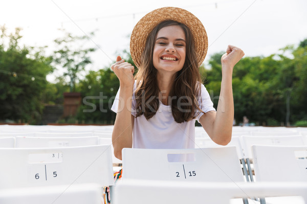 Excited young girl sitting at the city park outdoors Stock photo © deandrobot