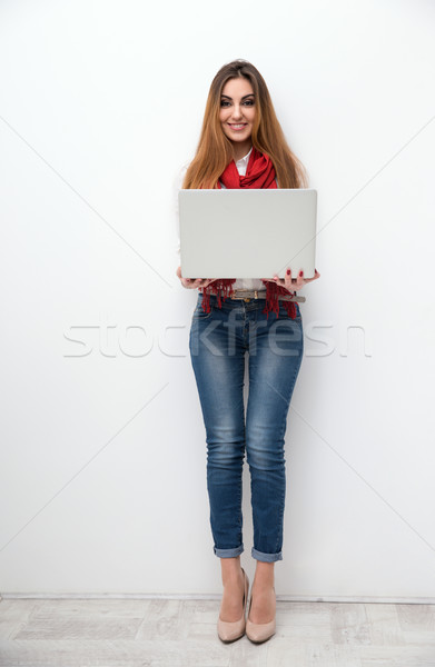 Full length portrait of a happy woman with laptop Stock photo © deandrobot