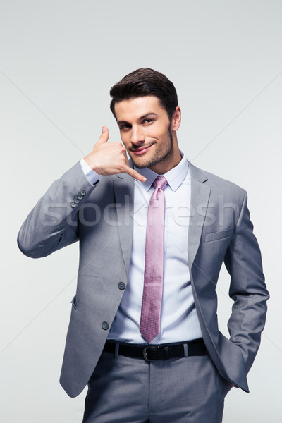 Stock photo: Handsome businessman shwoing call me gesture