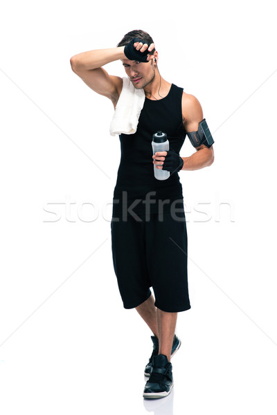 Tired sports man with towel and bottle with water Stock photo © deandrobot