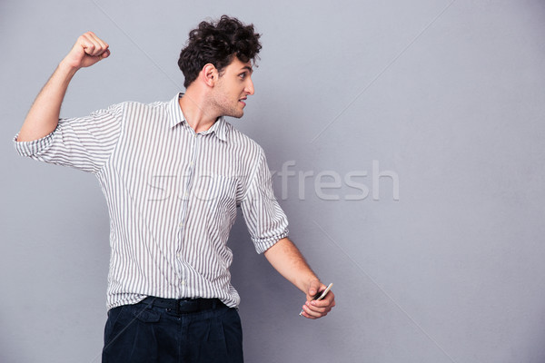 Angry young man clenching his fist  Stock photo © deandrobot