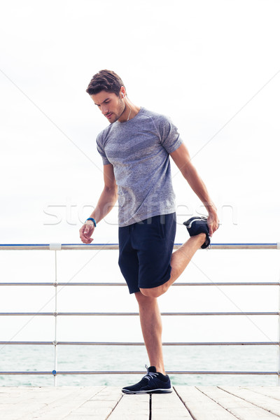 Man stretching legs outdoors Stock photo © deandrobot