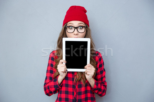 Scared woman covering her face with tablet computer Stock photo © deandrobot