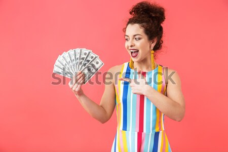 Cheerful pretty young woman holding colorful lollipop and laughing Stock photo © deandrobot