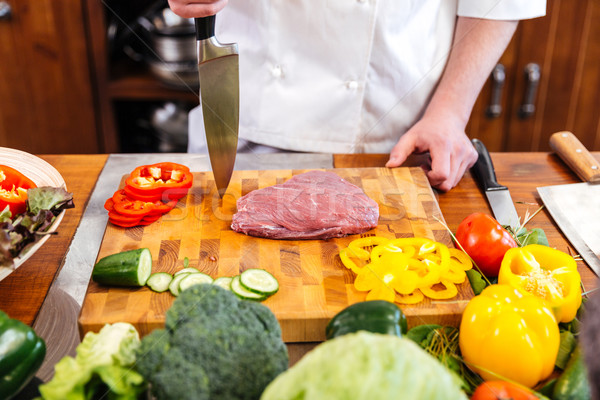 Cheif cook coooking meat and salad with fresh vegetables  Stock photo © deandrobot