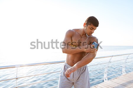 Athletic shirtless african sportsman training outdoors and showing biceps Stock photo © deandrobot
