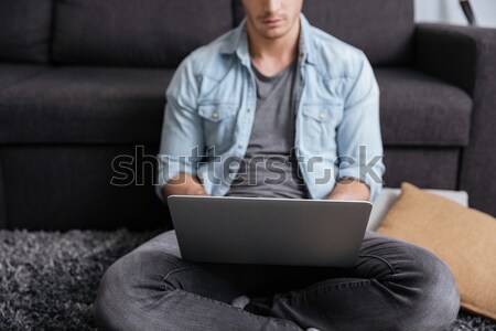 Gülen adam oturma halı dizüstü bilgisayar ev Stok fotoğraf © deandrobot