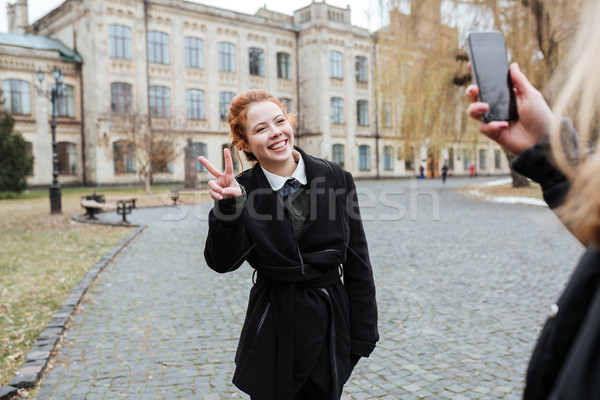 Stock photo: Woman posing for a picture with university building on background