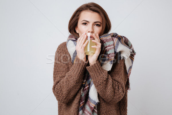 Sick young lady in sweater holding glass with medicine Stock photo © deandrobot