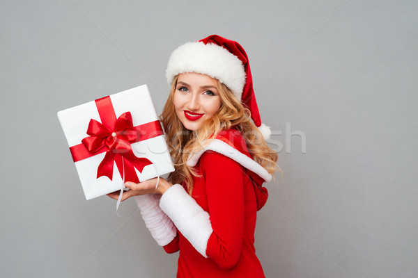 Smiling girl in red christmas outfit holding big gift box Stock photo © deandrobot
